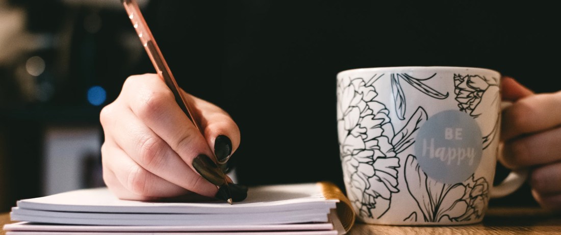 person holding white ceramci be happy painted mug